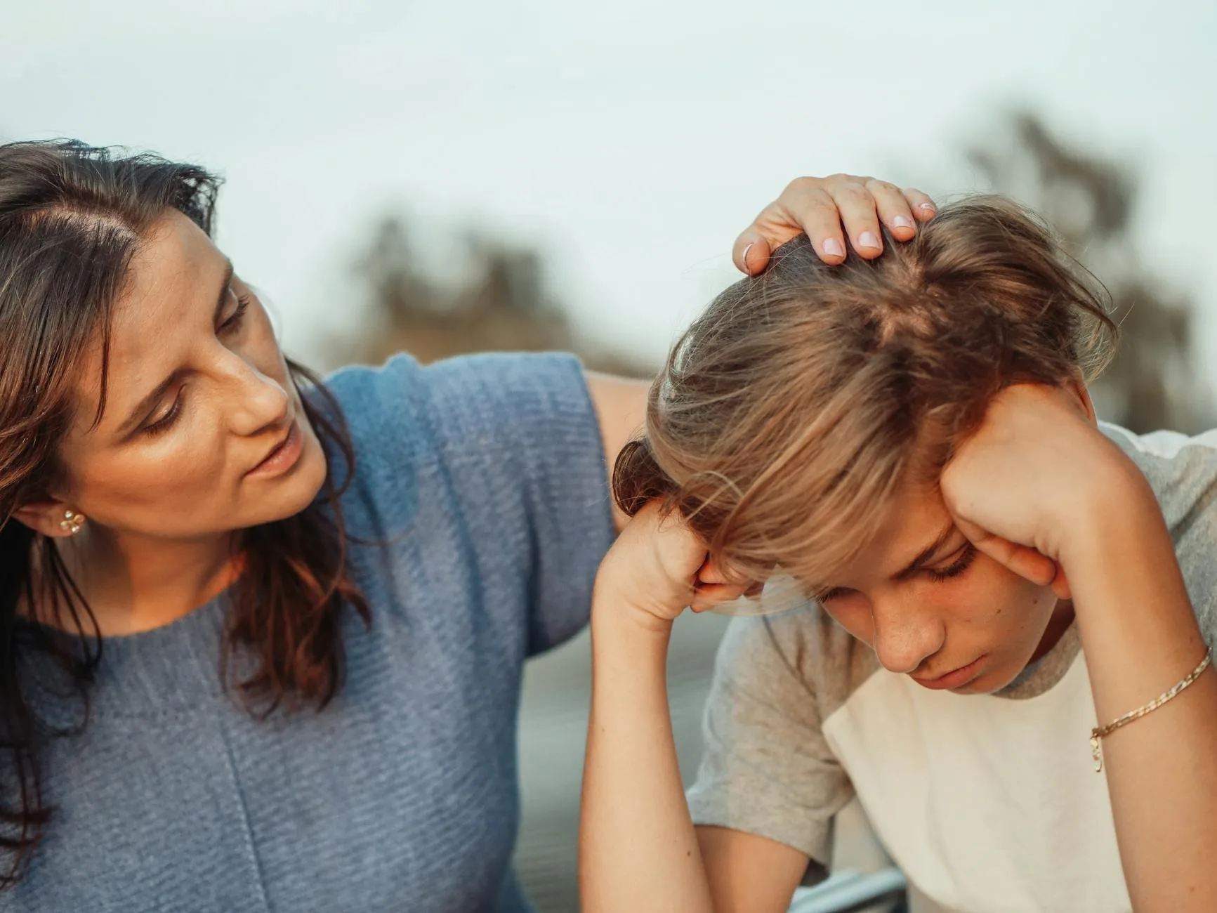 Jak wspierać rozwój emocjonalny dziecka w przedszkolu i w domu Mama wspierająca zasmuconego nastolatka w domowym zaciszu