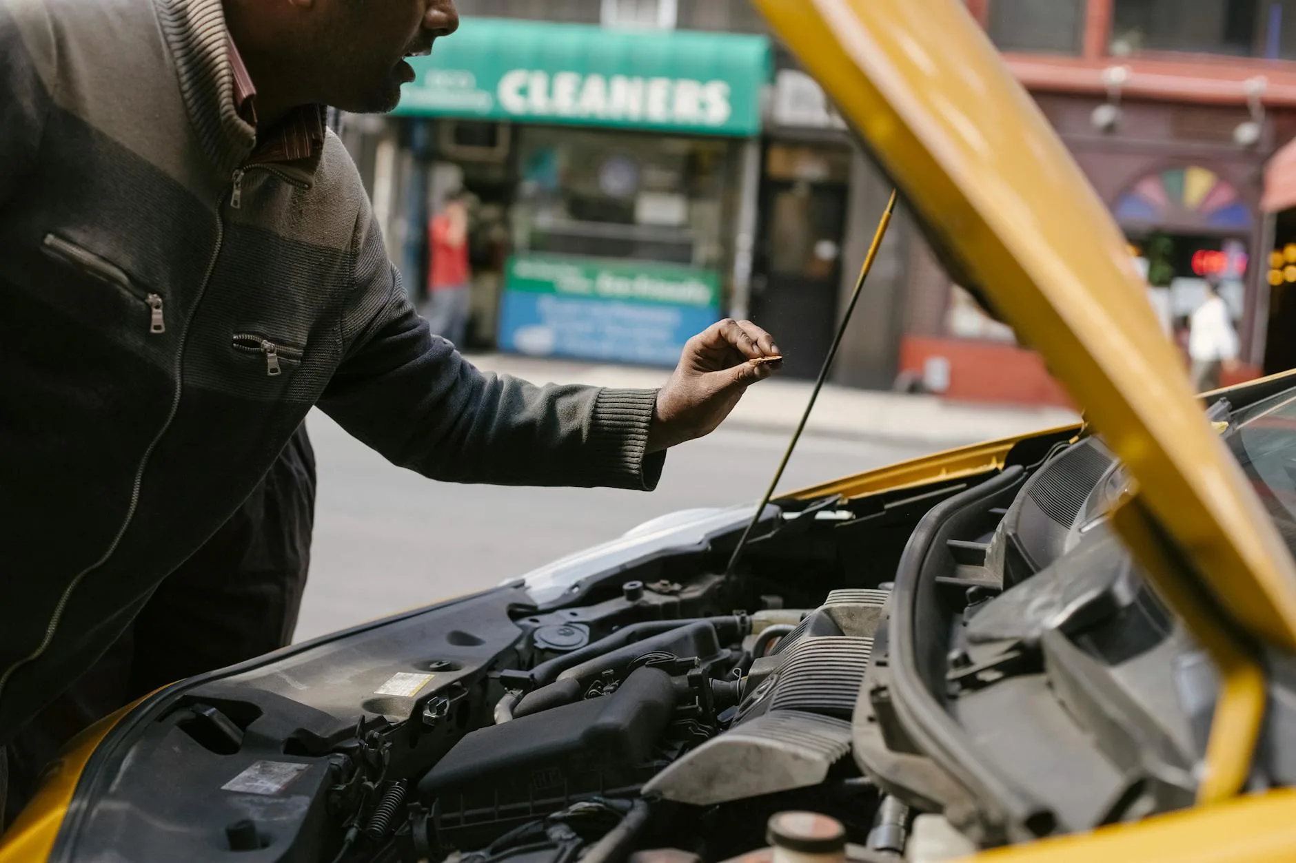 Jak sprawdzić historię serwisową Peugeota po VIN i uniknąć auta po poważnej naprawie Mechanik sprawdza silnik Peugeota zaparkowanego przy ulicy