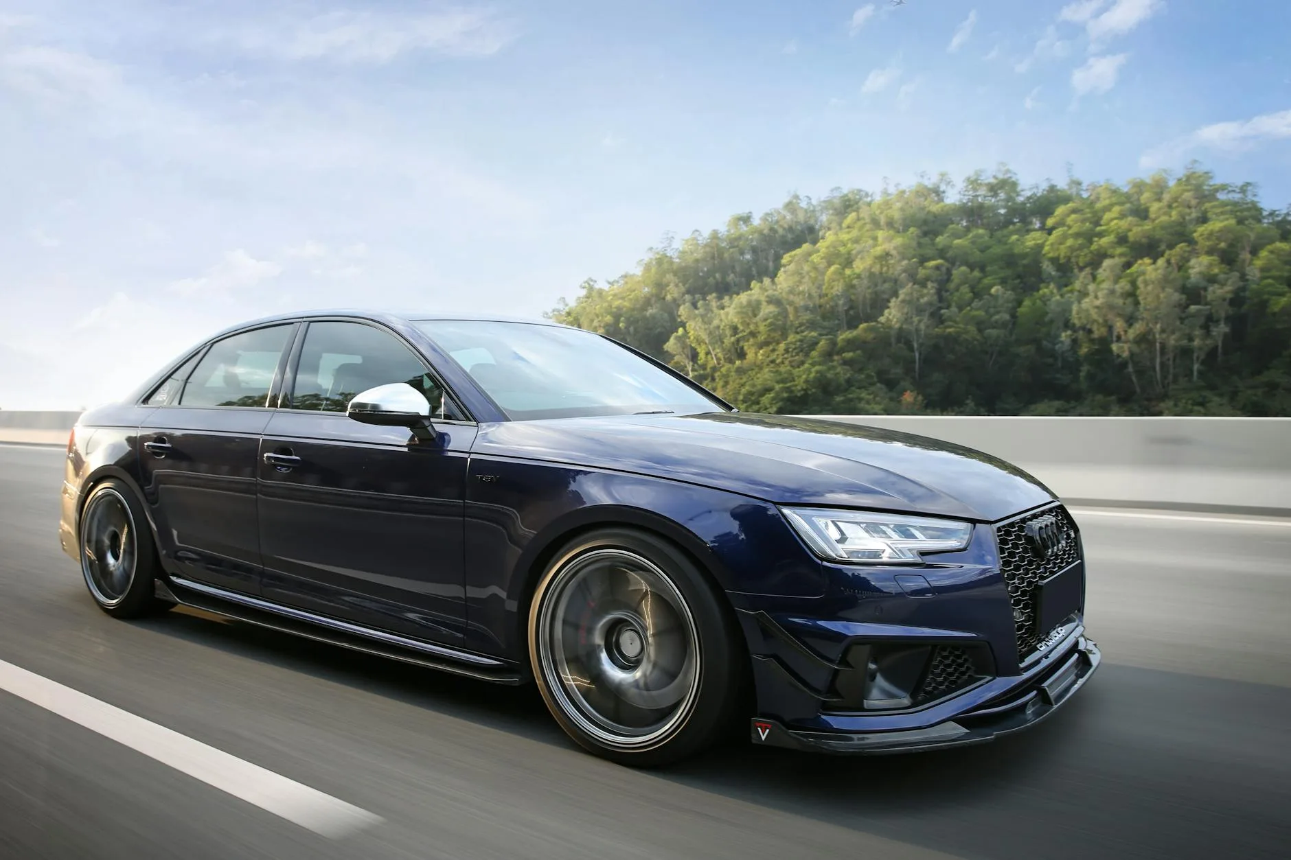 Niebieski sportowy sedan Cadillac jedzie szybko malowniczą autostradą