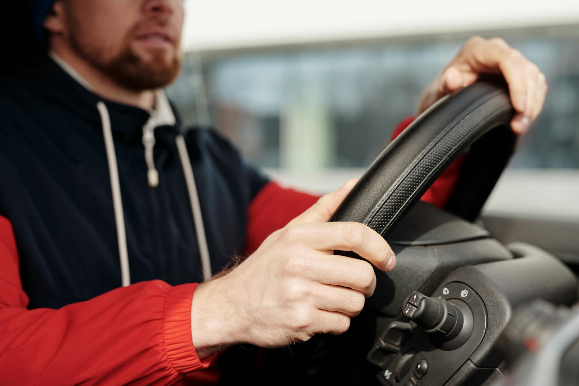Skupiony kierowca Subaru trzymający kierownicę we wnętrzu auta
