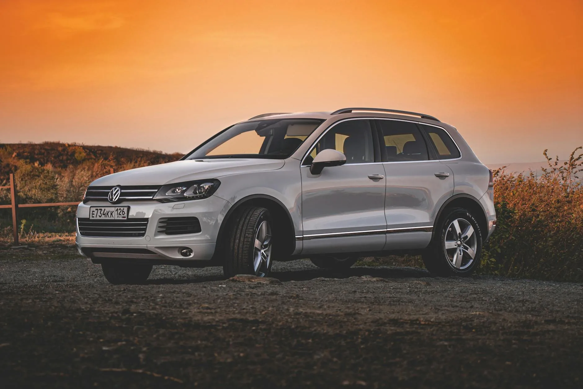 Biały SUV Volkswagen zaparkowany na zewnątrz o zachodzie słońca