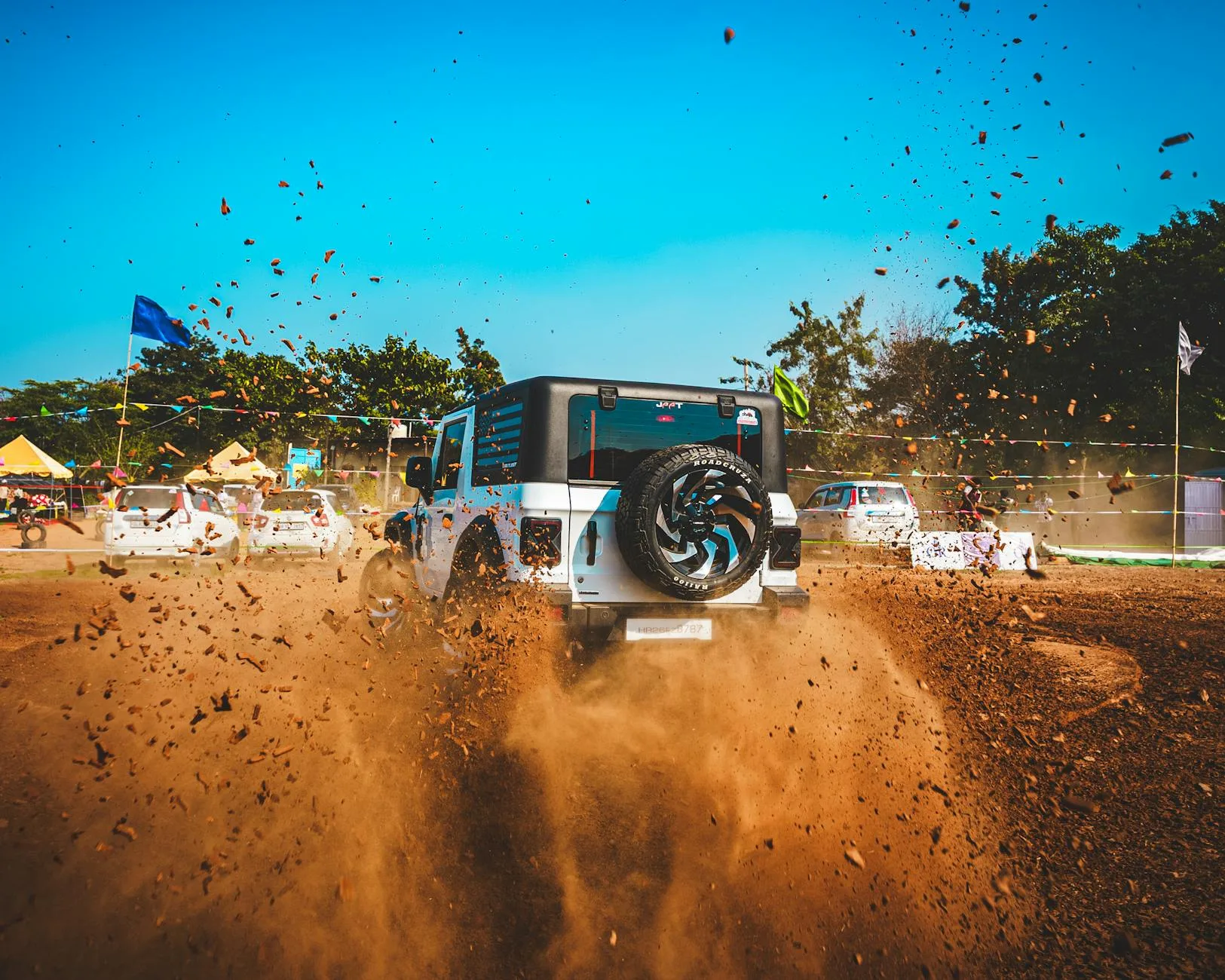 Suzuki Jimny jadące po zakurzonej, terenowej drodze