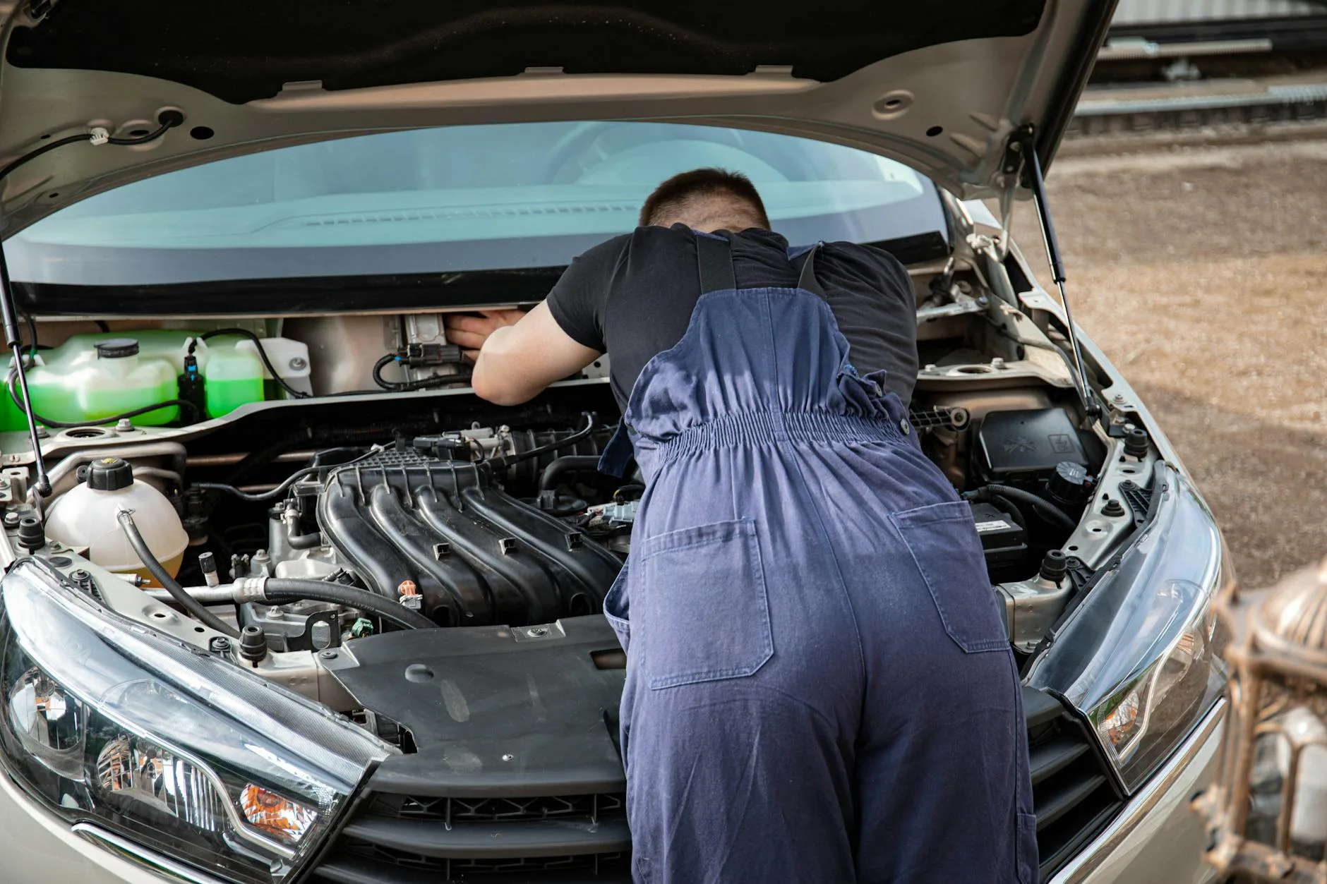 Changan po 50 tys. km: co się psuje i ile kosztują naprawy? Mechanik naprawia silnik samochodu Changan na zewnątrz