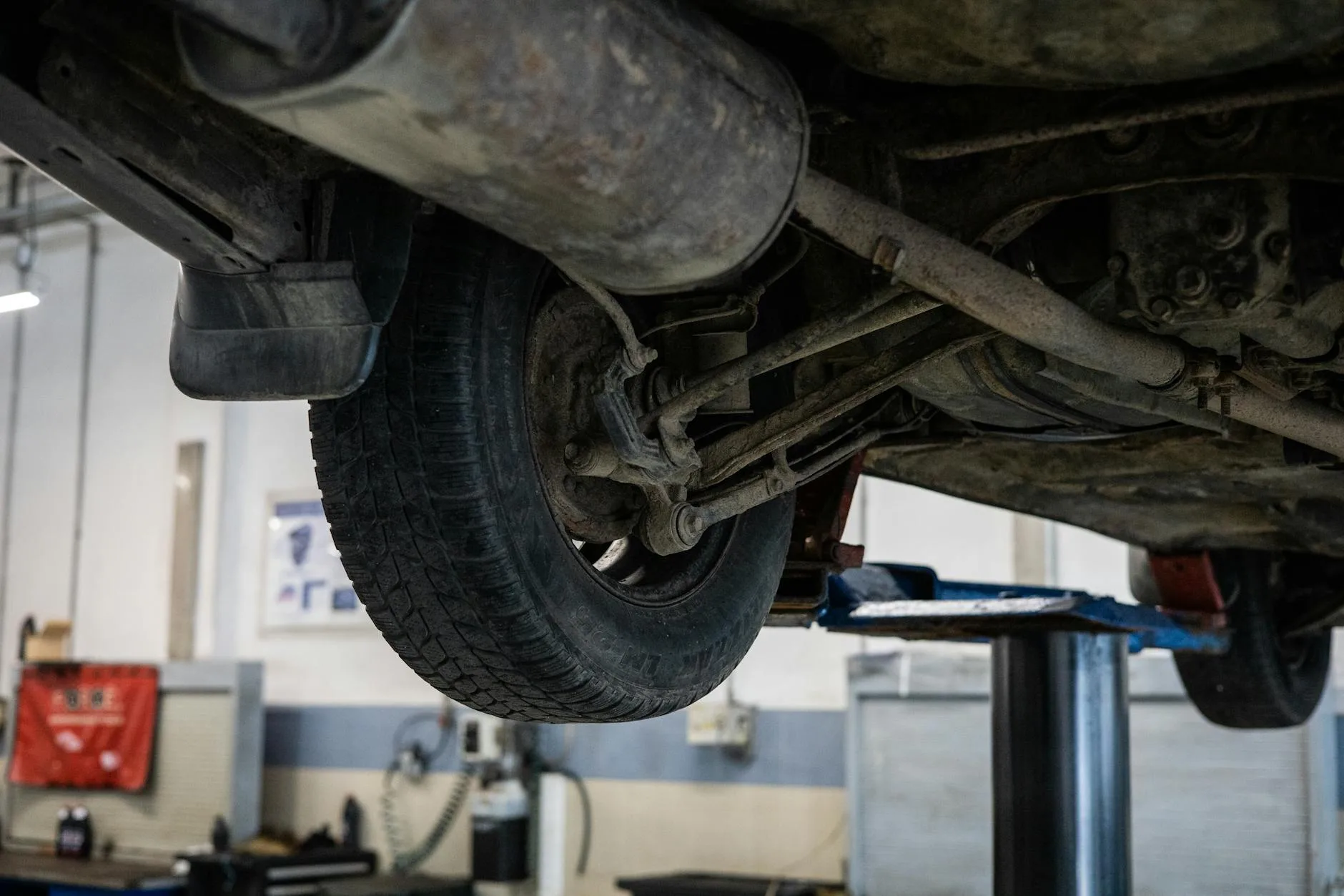 Mechanik ogląda podwozie Peugeota 208 na podnośniku w serwisie