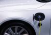 BYD kontra Toyota: czy hybrydy DM i mają sens poza miastem? Białe auto elektryczne podłączone do ładowania, zbliżenie gniazda